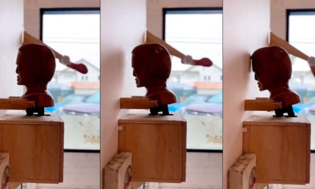 Artist creates “most relatable sculpture ever” of a human head that constantly bangs its head against the wall