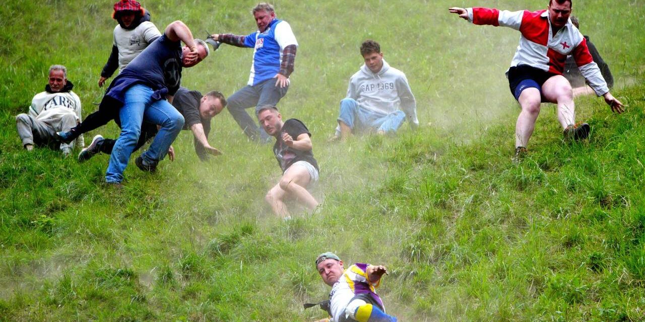 Cheese-loving daredevils hurl themselves down Cooper’s Hill in Gloucestershire for famous race